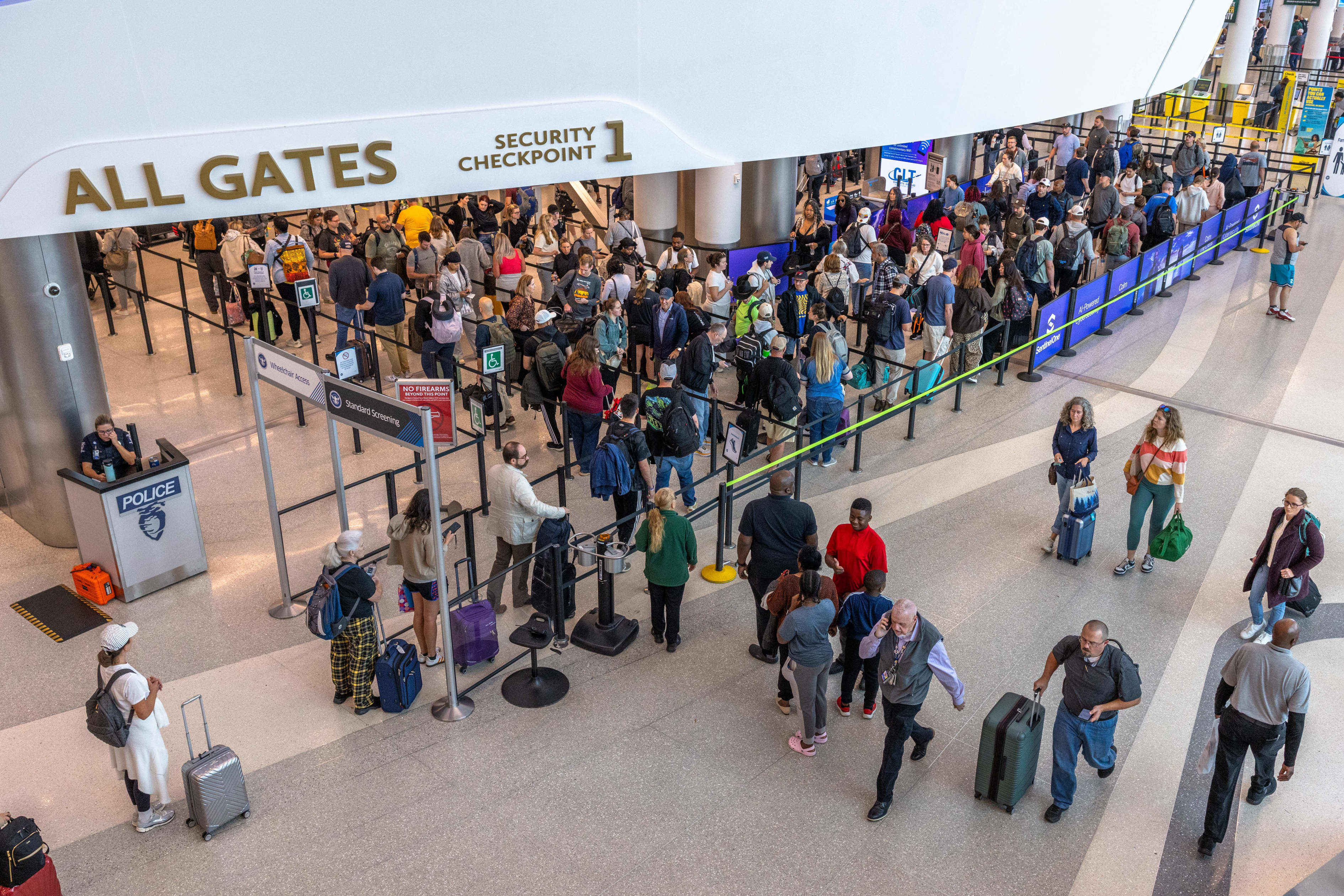 People waiting in line at a security checkpoint at Charlotte-Douglas International Airport.