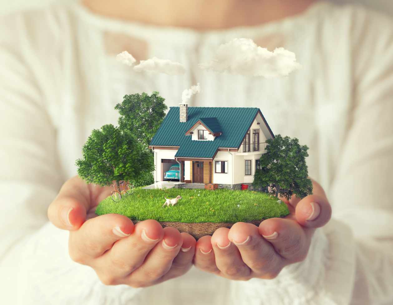 Hands holding a small house, yard, and trees.