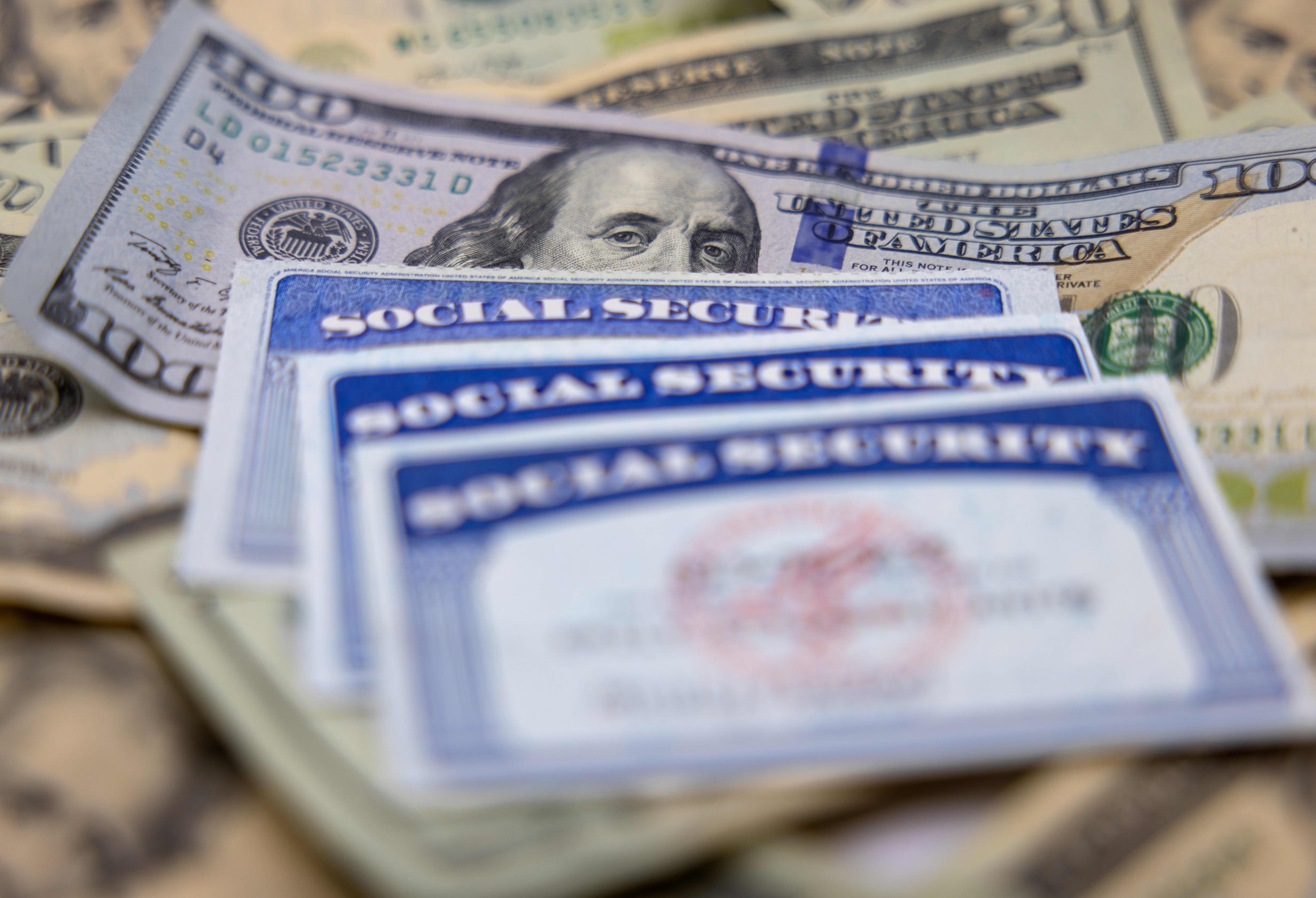 Social Security cards placed on top of dollar bills.