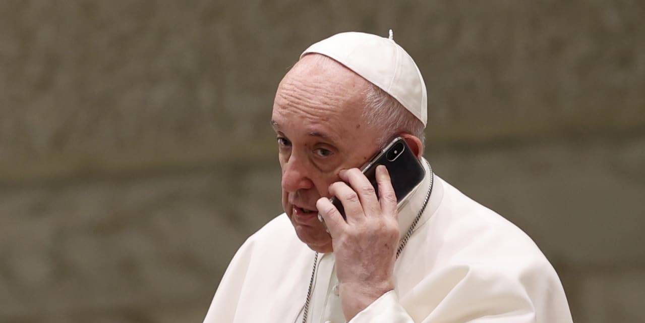 Pope Francis takes an urgent phone call during his weekly general
