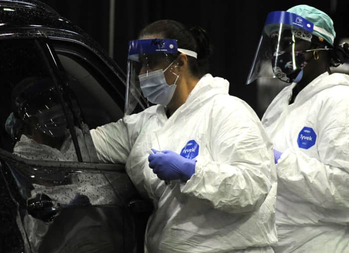 workers testing a person in drive up clinic