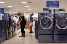 SCHAUMBURG, ILLINOIS - AUGUST 17: Customers look over appliances in a department store on August 17, 2021 in Schaumburg, Illinois. Spending at U.S. retailers fell 1.1% last month compared with June according to a Commerce Department report issued today. (Photo by Scott Olson/Getty Images)