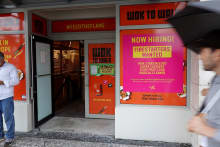 MIAMI BEACH- NOVEMBER 05: A ''Now Hiring" sign hangs near the entrance to the Wok To Walk restaurant on November 05, 2021 in Miami Beach, Florida. The Labor Department reported today that the U.S. job market in October showed that non-farm payrolls rose more than expected and that the unemployment rate fell to 4.6%. (Photo by Joe Raedle/Getty Images)