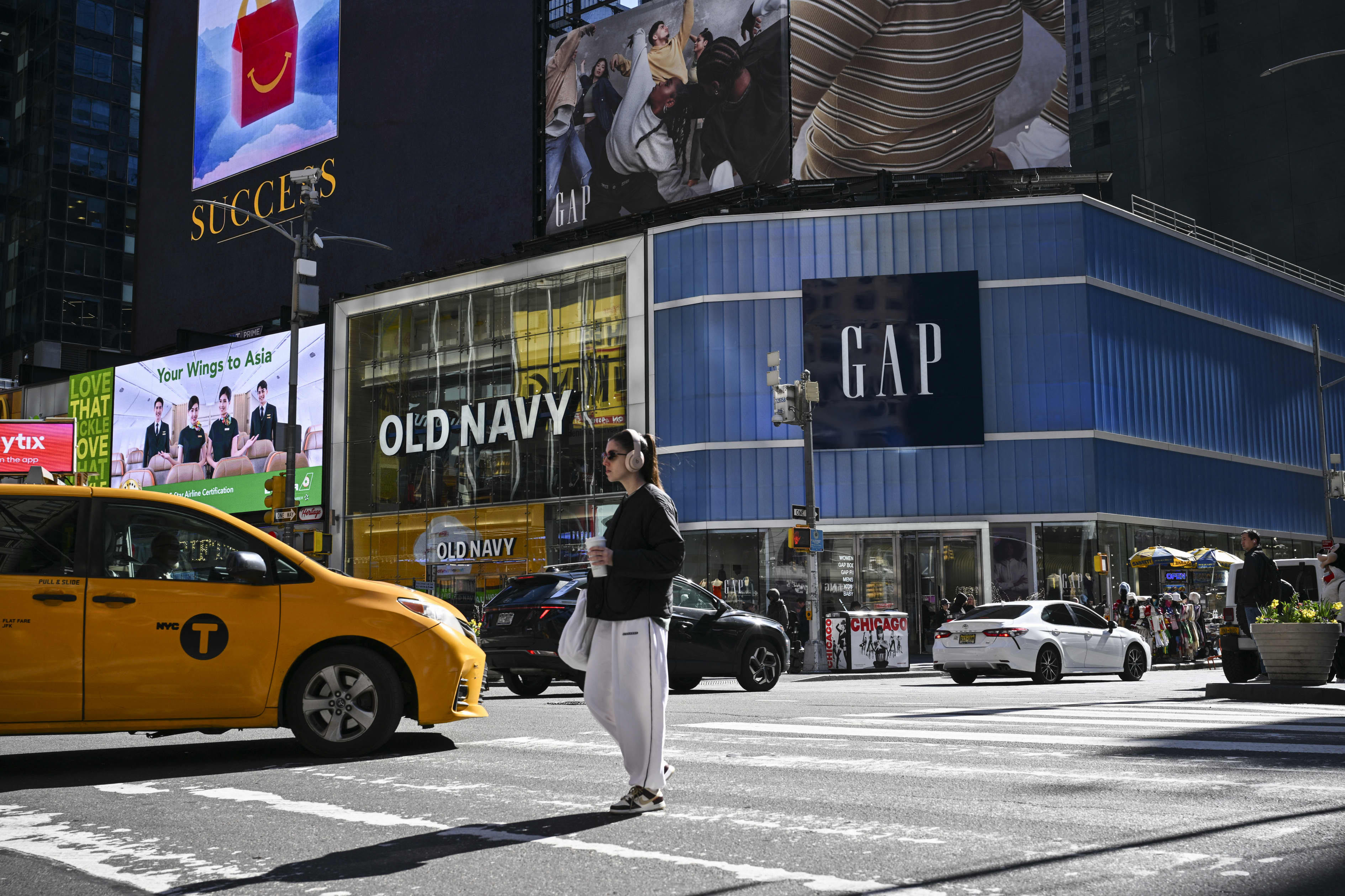 People walk by Old Navy and Gap retail stores in Times Square, New York City.