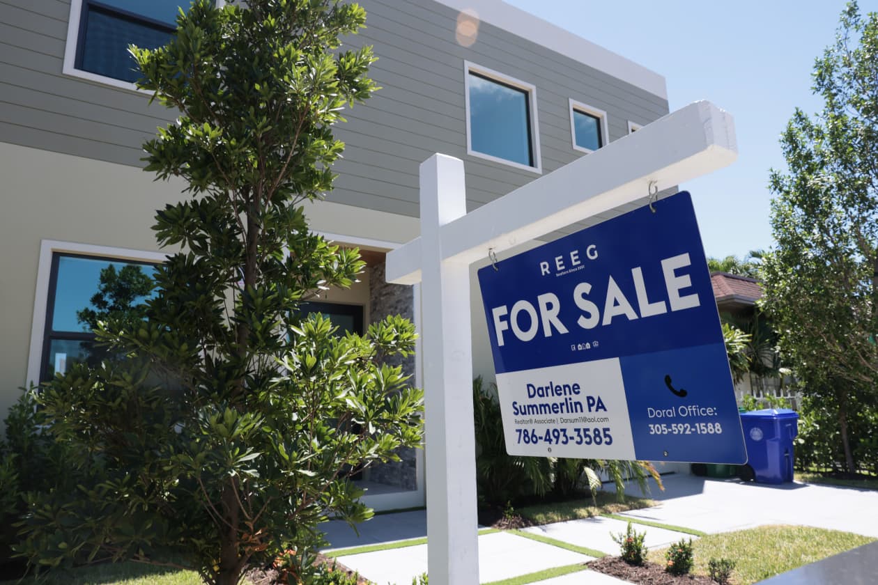 A "For Sale" sign in front of a modern house.