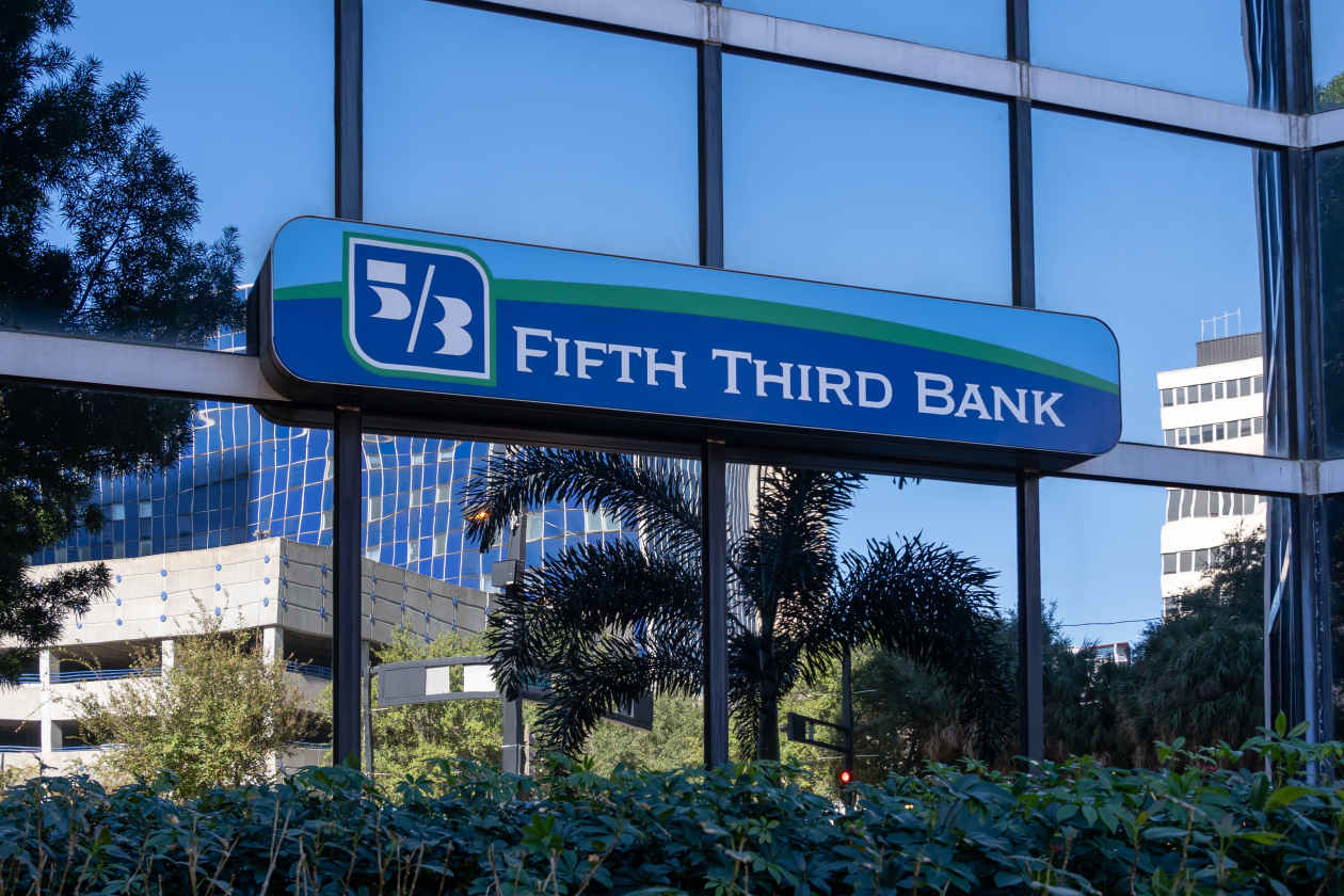Fifth Third Bank sign on a building with large windows reflecting palm trees.