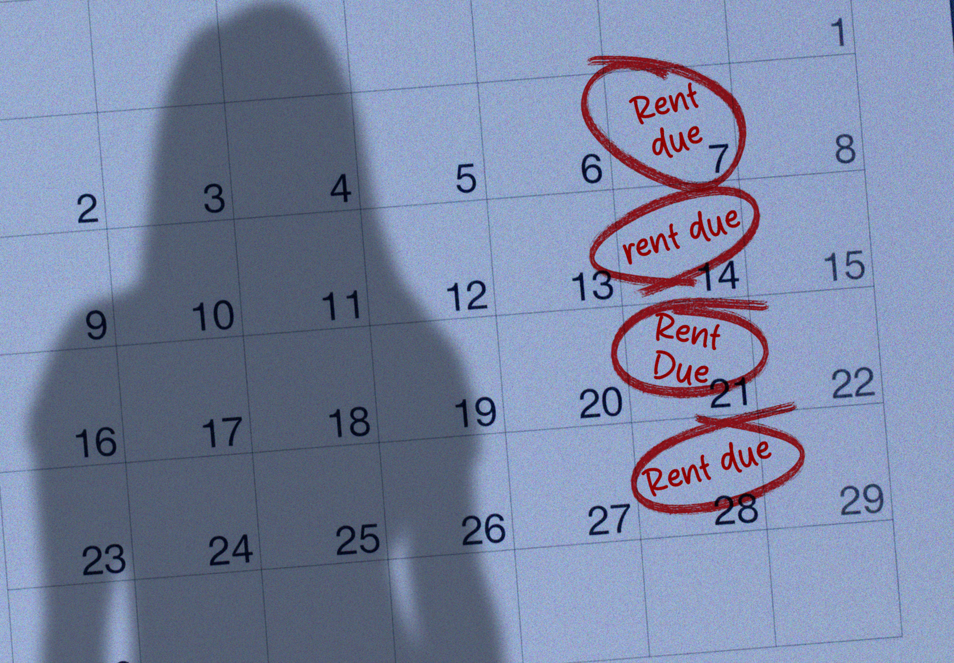 A calendar page with "Rent due" circled in red on the 7th, 14th, 21st, and 28th, with a person's shadow cast over it.