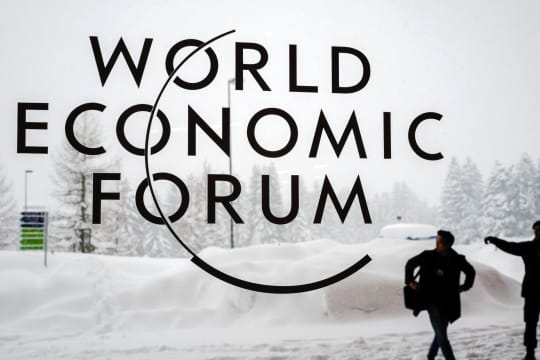 TOPSHOT - A security guard show the way to a man outside of the Davos Congress Centre under snow ahead of the opening of the World Economic Forum (WEF) 2018 annual meeting, on January 22, 2018 in Davos, eastern Switzerland. US President Donald Trump's participation at the World Economic Forum in Davos, Switzerland next week could be thrown into question now that the federal government has partially shut down over budget wrangling, the White House said on January 20. / AFP PHOTO / Fabrice COFFRINI (Photo credit should read FABRICE COFFRINI/AFP via Getty Images)
