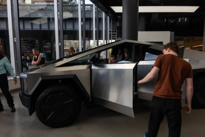 A Tesla dealership visitor in Manhattan examines the large, angular Cybertruck in October.