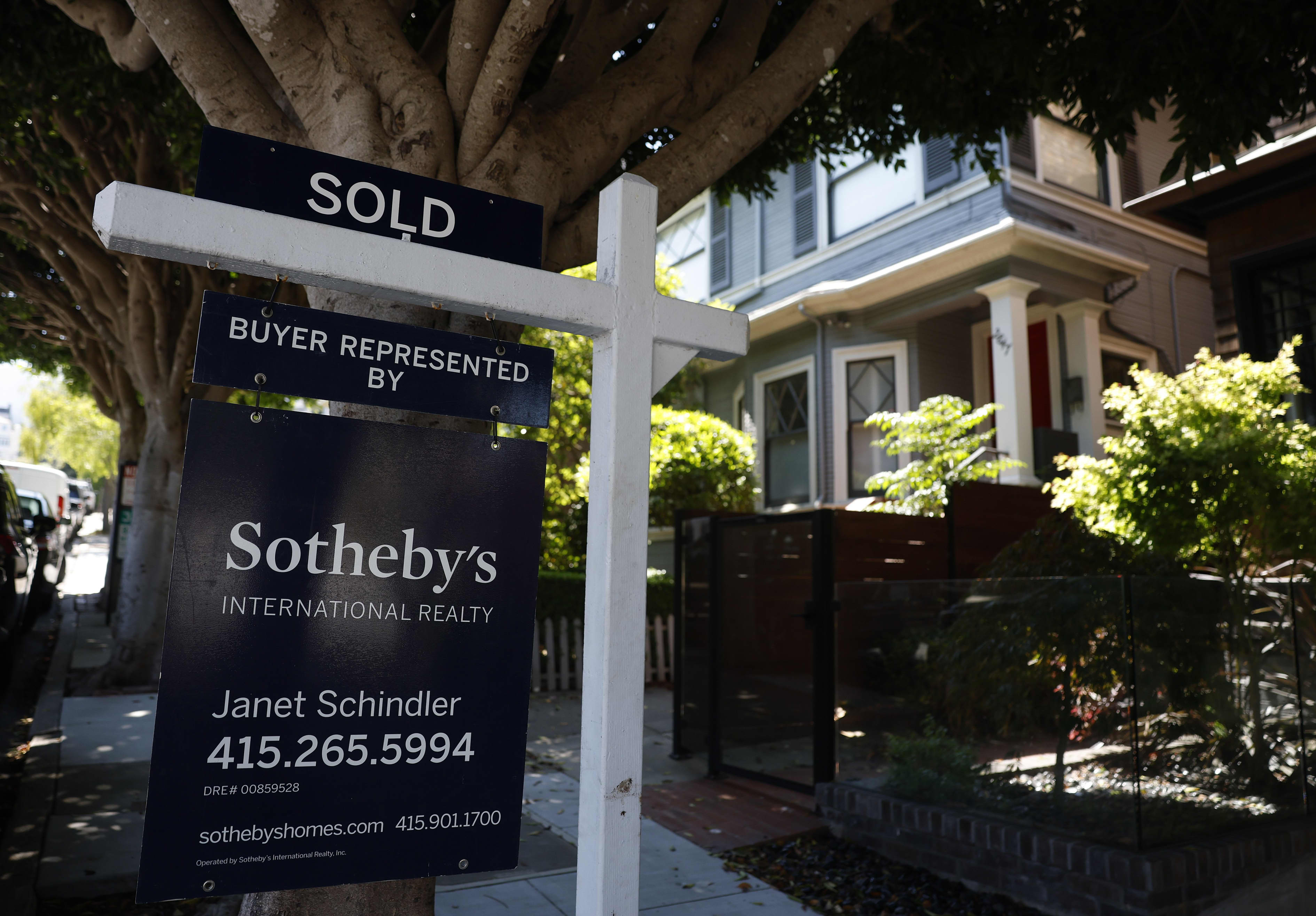 A "SOLD" real estate sign from Sotheby's International Realty in front of a house.