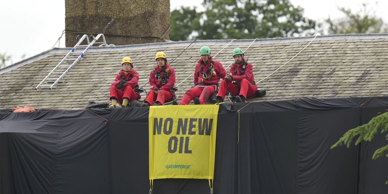 Greenpeace demonstrators drape U.K. prime minister’s house in black to protest oil drilling expansion in North Sea