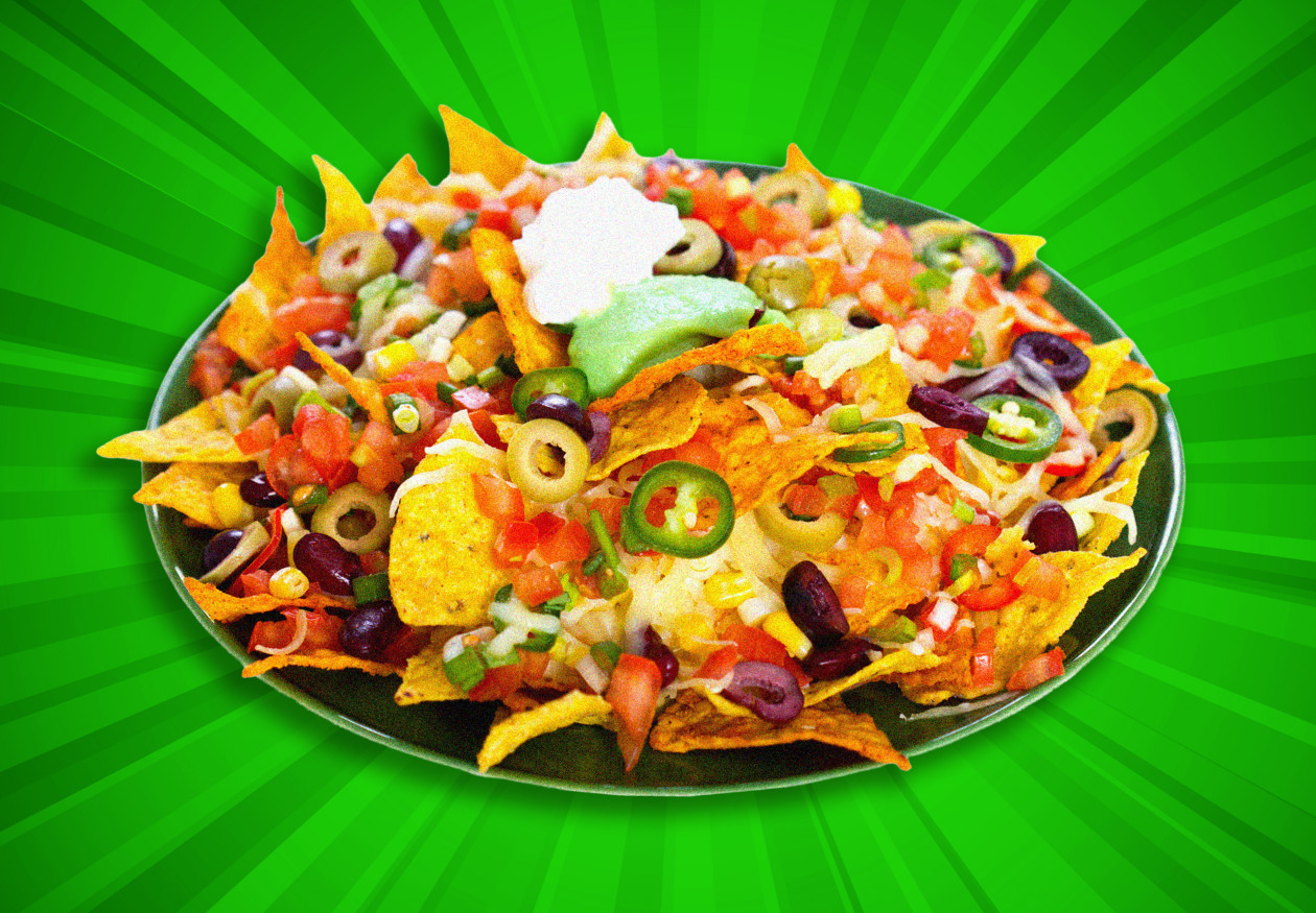 Nachos topped with cheese, olives, jalapeños, beans, and salsa, with guacamole and sour cream on a green plate.