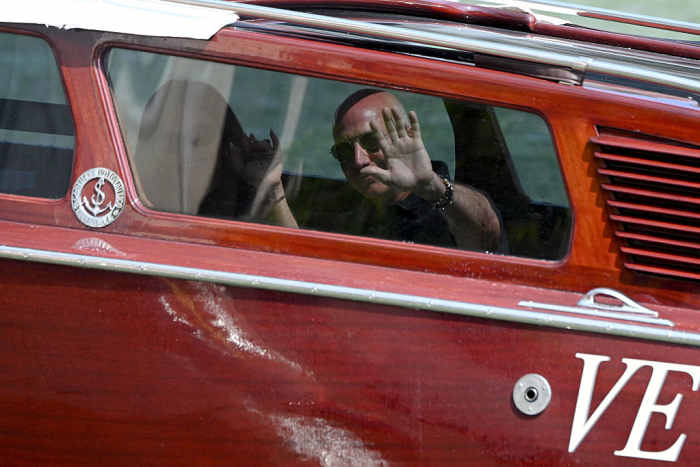 Jeff Bezos and Lauren Sanchez waving from a boat.